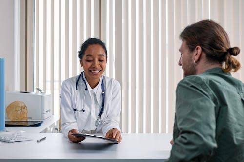 A doctor asking for a patient feedback in her office