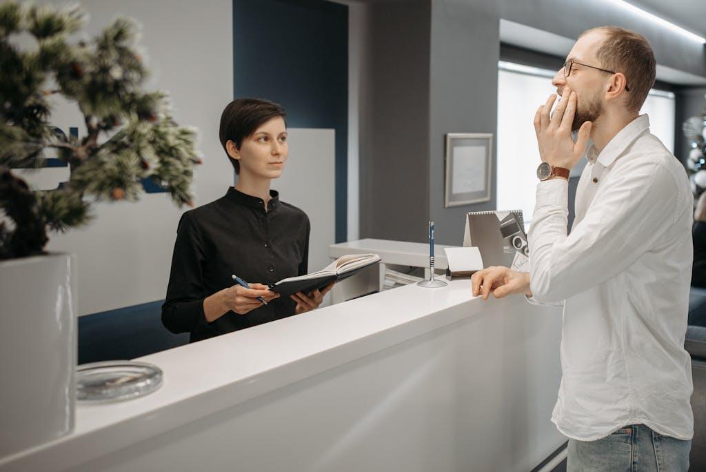 A front desk staff at a dental practice interacting with a patient.